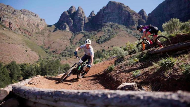 Two bikers heading through a narrow crate alley-way