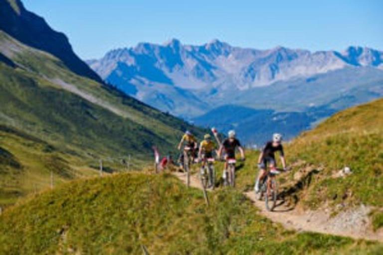 Bikers on a path with a mountain framing their ride