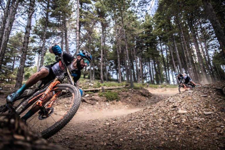 A biker taking a steep curve on a dirt path